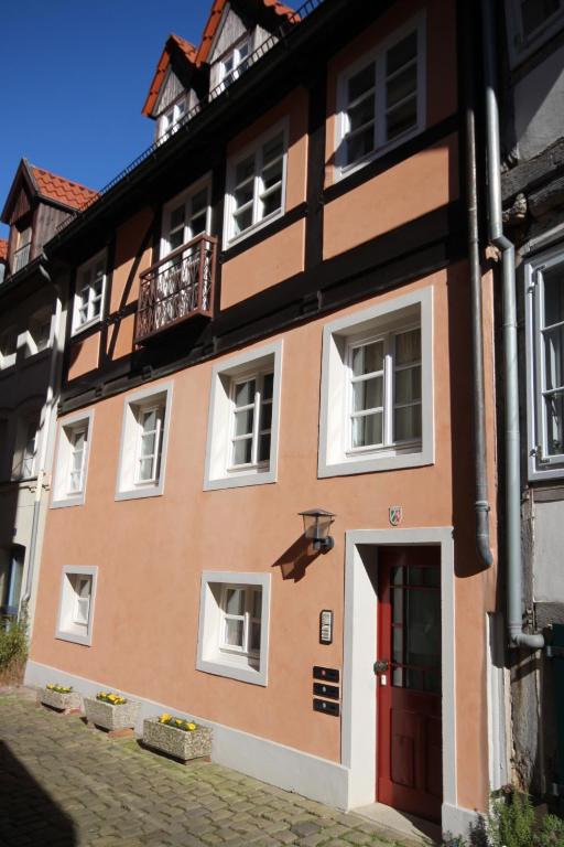 ein orangefarbenes und weißes Gebäude mit einer roten Tür in der Unterkunft Wohnen auf der historischen Stadtmauer im Herzen von Detmold in Detmold