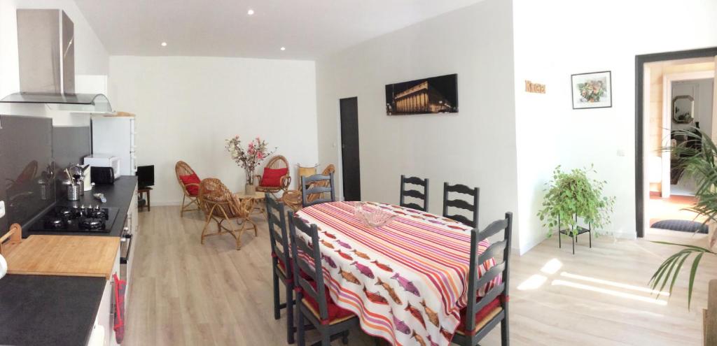 a kitchen and living room with a table with a striped table cloth at Logis de Villemaurine in Saint-Émilion