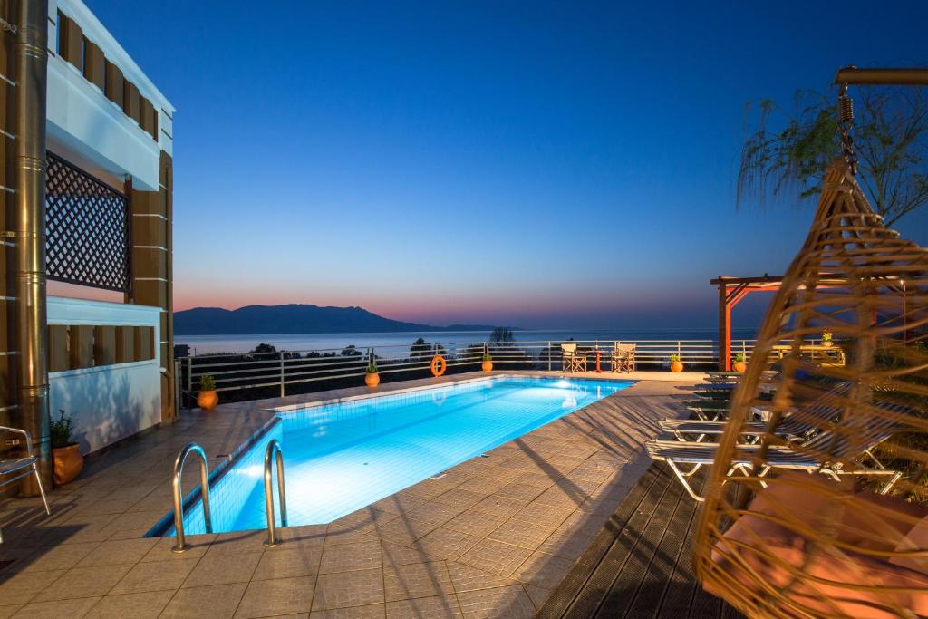 a swimming pool with a view of the ocean at Ben's Homes in Nopíyia