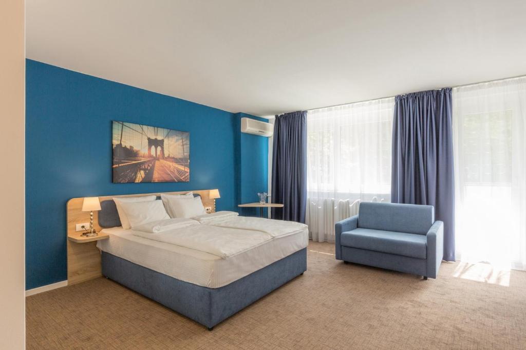 una camera con un grande letto e una parete blu di Premium Crown Suites a Belgrado