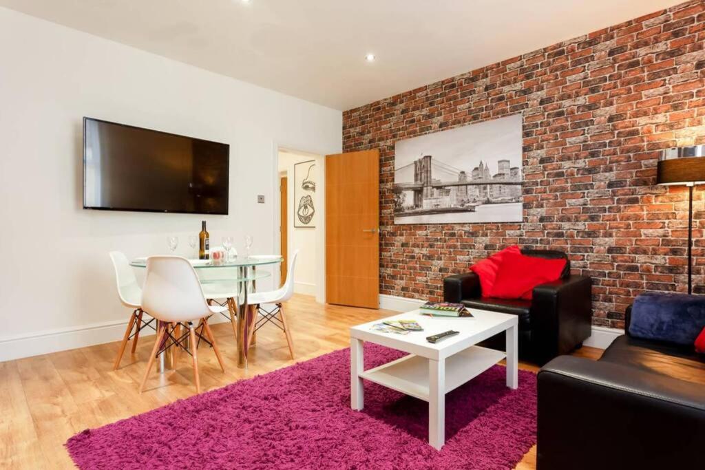 a living room with a brick wall at Stylish 2 bed 2 bath *Close To Beach and Centre with parking* in Bournemouth