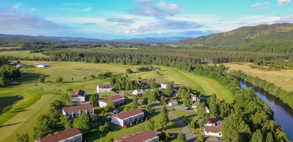 uma vista aérea de uma casa num campo de golfe ao lado de um rio em Macdonald Spey Valley Resort em Aviemore