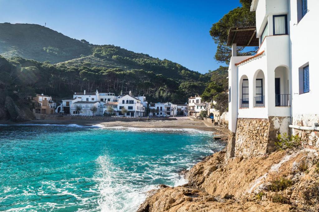 a group of houses on a cliff next to the ocean at Casa Malva Sa Tuna in Begur