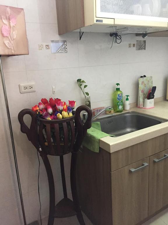 a kitchen with a bowl of fruit on a chair next to a sink at Amicasa Guesthouse in Hualien City