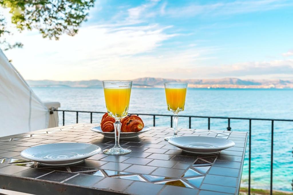 een tafel met twee glazen sinaasappelsap en wat eten bij Sutivan Best Apartments in Sutivan