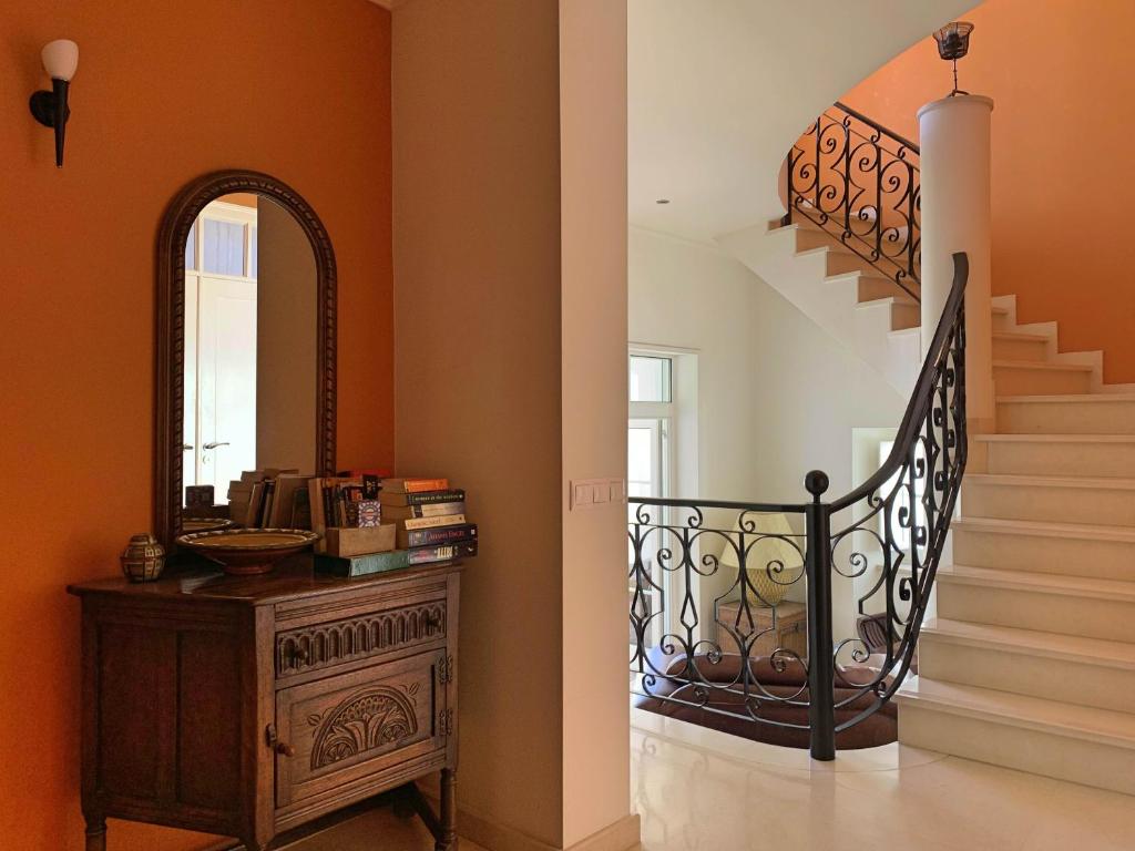 a hallway with a staircase with a mirror and a dresser at Residence Lagos in Lagos