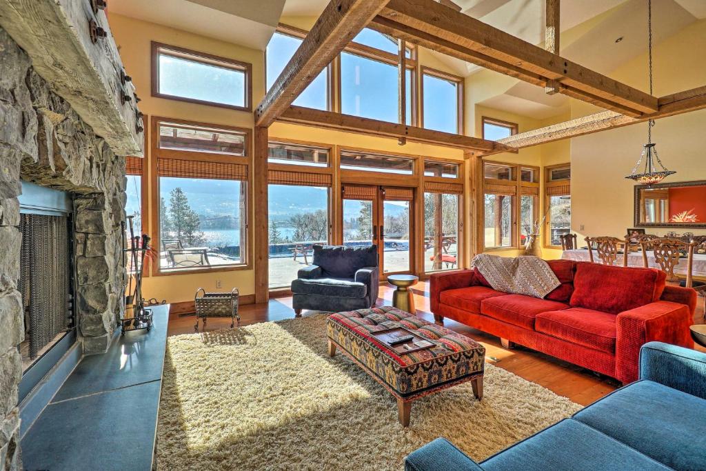 a living room with a red couch and a fireplace at Country Villa on Kalamalka Lake with Pool! in Oyama