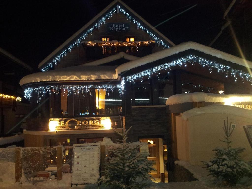 a building with christmas lights on it at night at Chalet Hotel Régina in Les Gets