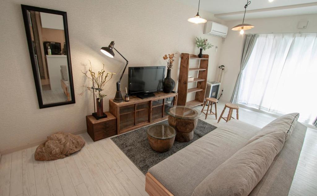 a living room with a couch and a television at Premiere N21 / Vacation STAY 7450 in Sapporo