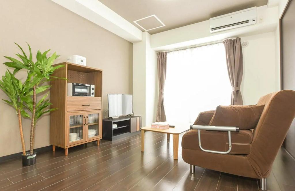 a living room with a couch and a chair at Suncourt Minami 6jo Nibankan / Vacation STAY 7447 in Sapporo