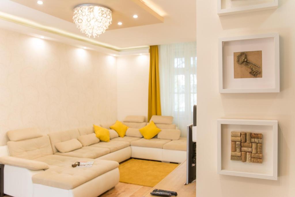 un soggiorno con divano bianco e cuscini gialli di Cork Apartman a Eger