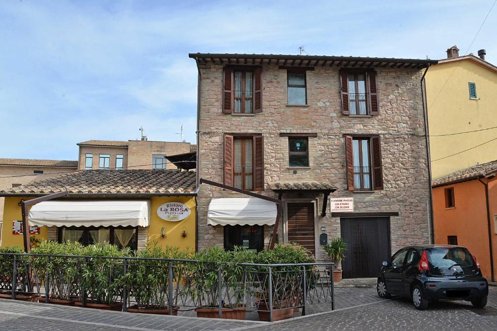 una piccola auto parcheggiata di fronte a un edificio di Camere Paolo ad Assisi