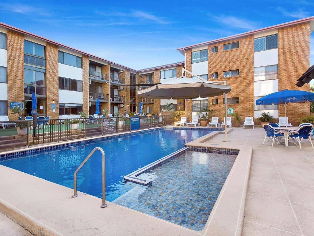 uma piscina num complexo de apartamentos com um hotel em Sandcastles Holiday Apartments em Coffs Harbour