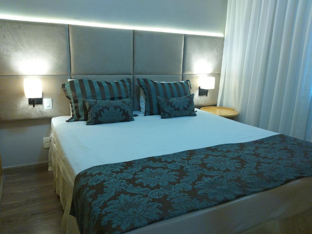 a bedroom with a large bed with two pillows at Residencial Luxo Moema - Macuco in Sao Paulo