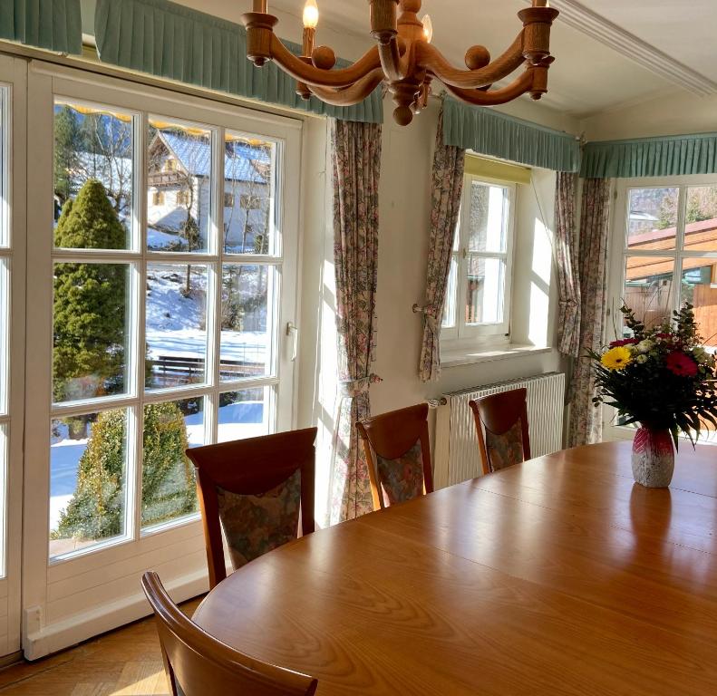 een eetkamer met een houten tafel en ramen bij Apartment Linda in Abtenau