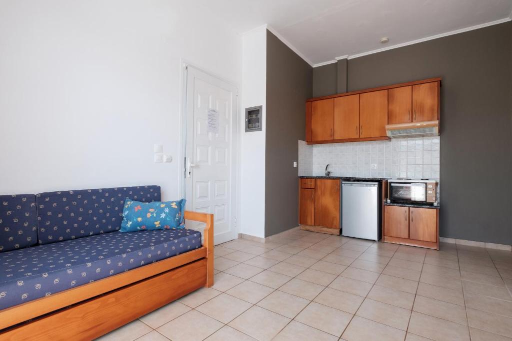 a living room with a couch and a kitchen at Hotel Club Maria Sidari in Sidari