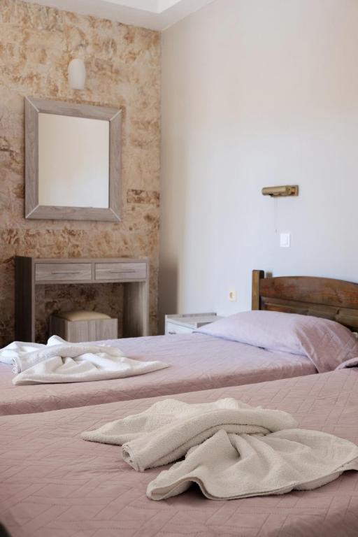a bedroom with two beds and a mirror on the wall at Hotel Club Maria Sidari in Sidari
