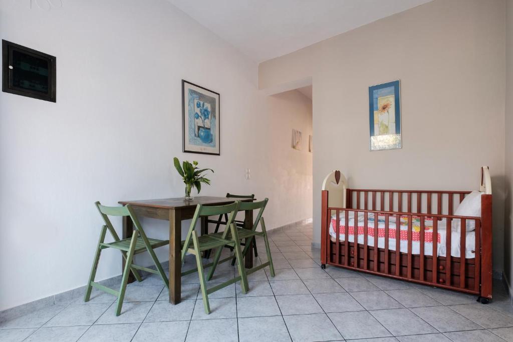 a dining room with a table and chairs and a crib at Hotel Club Maria Sidari in Sidari