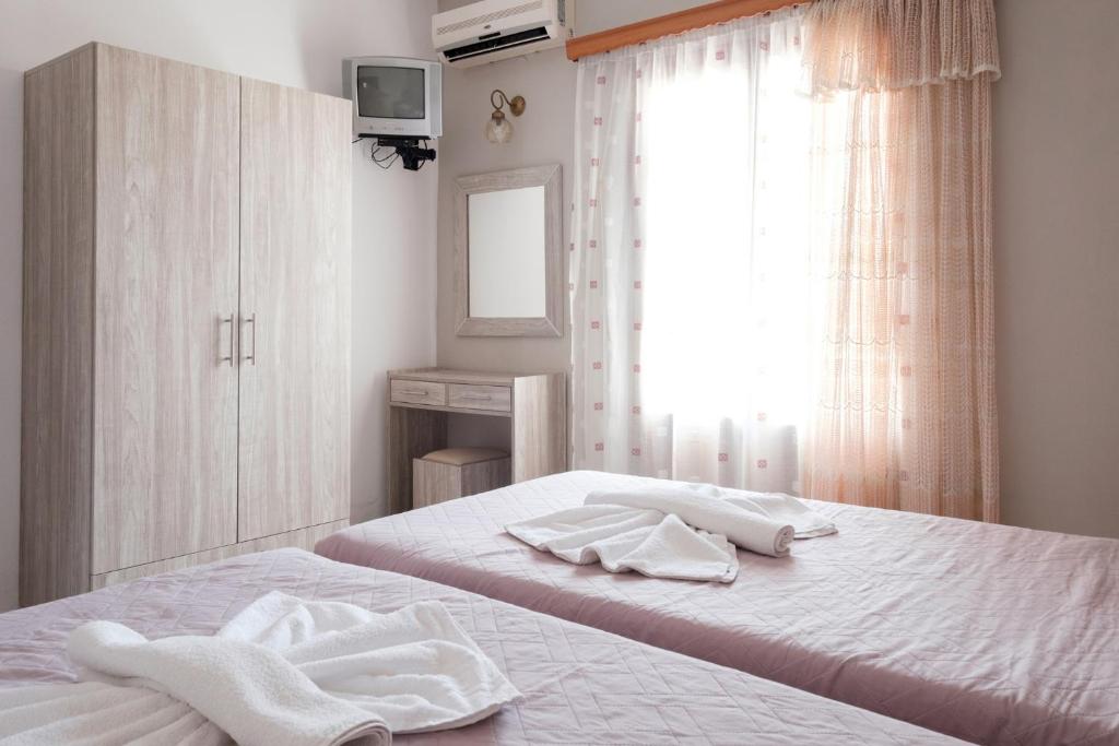 a bedroom with two white towels on a bed at Hotel Club Maria Sidari in Sidari