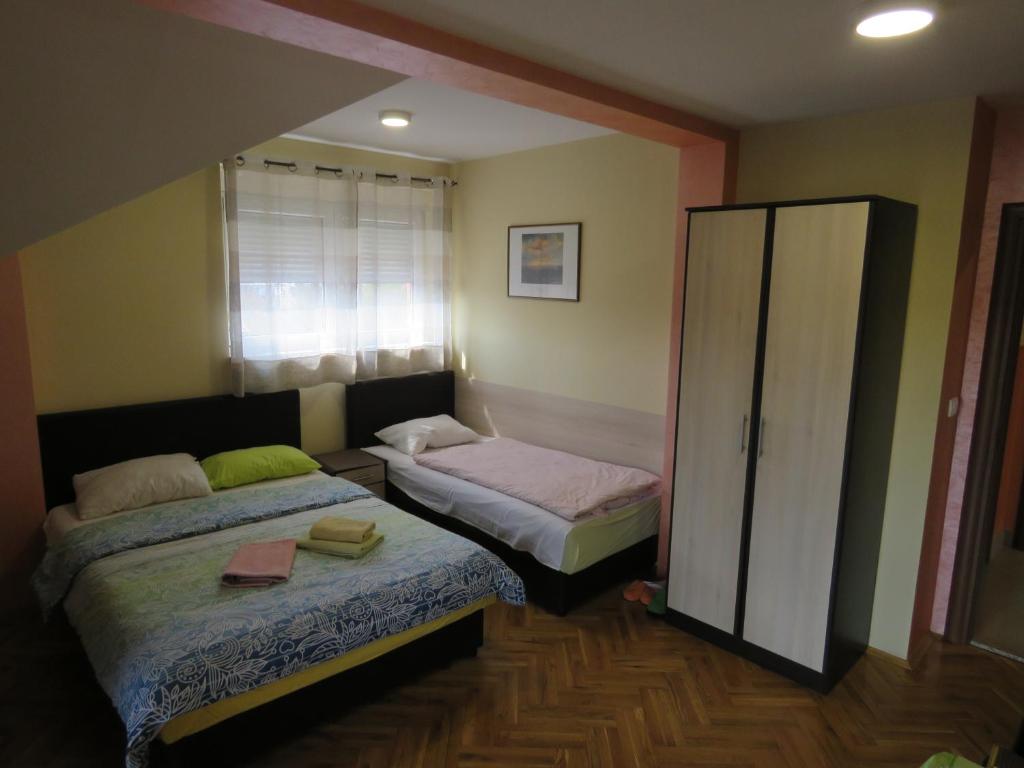 1 dormitorio con 2 camas y espejo en Hotel Apartments Bella Mare Belgrade, en Belgrado