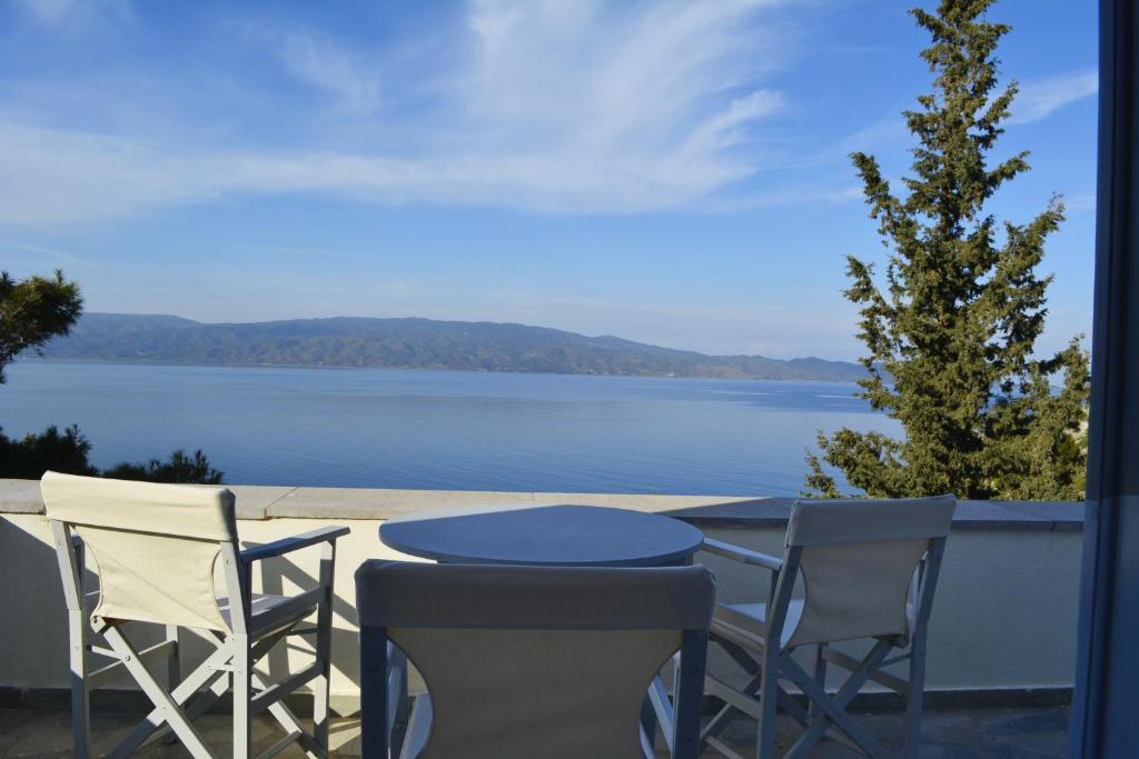 stół i krzesła na balkonie z widokiem na jezioro w obiekcie Pine Trees and Sea View Houses in Hydra - Daphne, Chloe, Myrto, Eleni w mieście Hydra