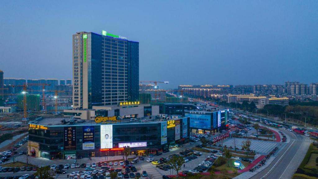 a city with a tall building and a lot of traffic at Holiday Inn Express Ningbo Fenghua, an IHG Hotel in Ningbo