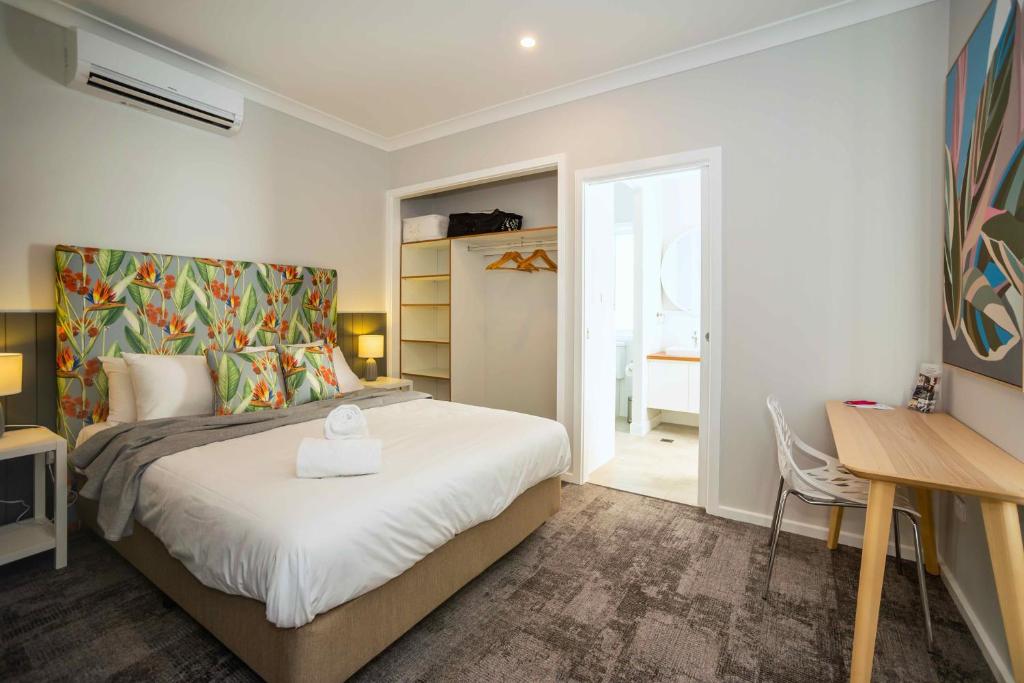 una camera con letto, scrivania e tavolo di Kirsten Accommodation Parkes a Parkes