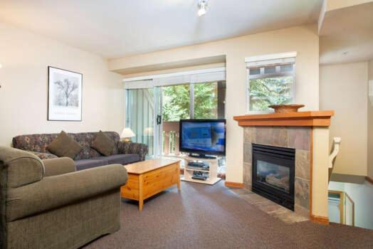 a living room with a couch and a fireplace at Sunpath by Outpost Whistler in Whistler