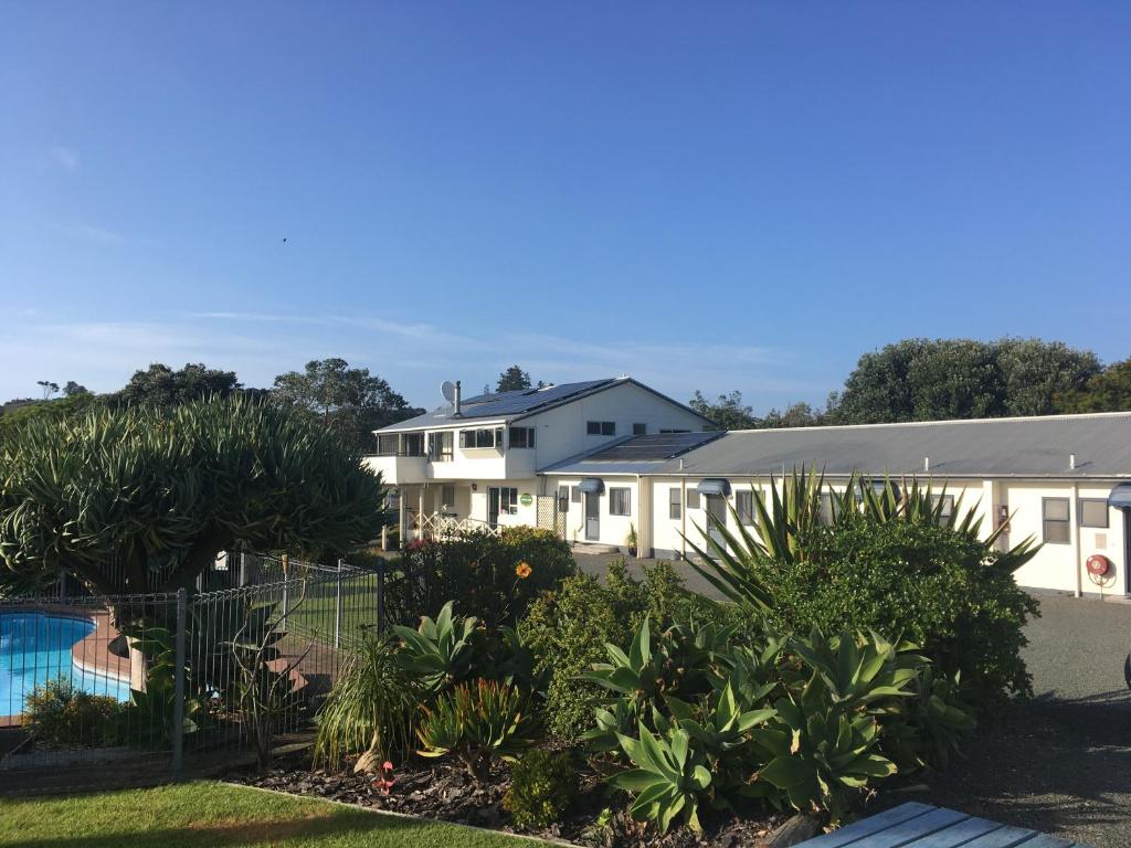 a house with a swimming pool and plants at Pukenui Lodge Motel in Pukenui