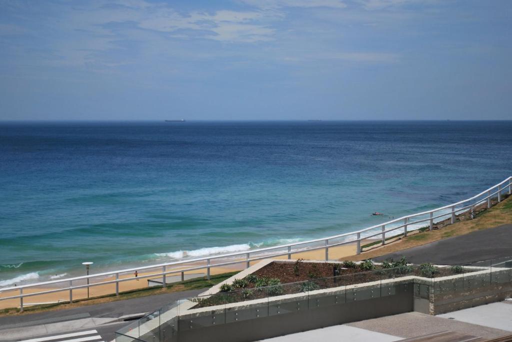 a view of the ocean from a balcony at Novotel Newcastle Beach in Newcastle