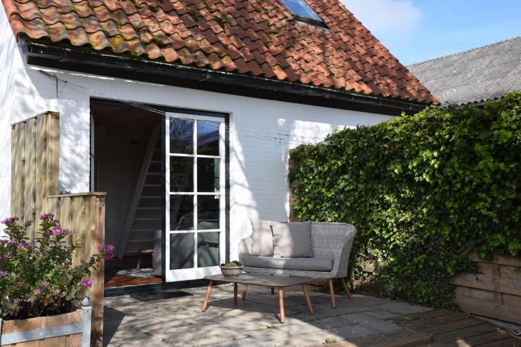 einen Stuhl auf einer Terrasse vor einem Haus in der Unterkunft Bij Lutske in Hollum