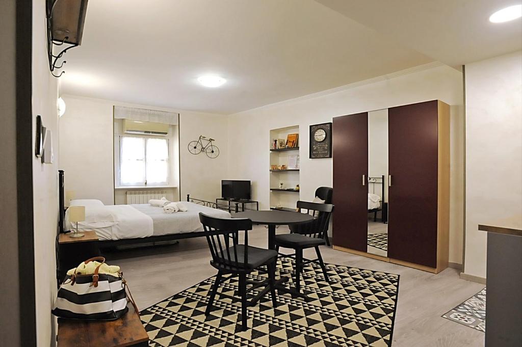 um quarto com uma cama, uma mesa e cadeiras em Cozy studio in Turin city center by Wonderful Italy em Turim