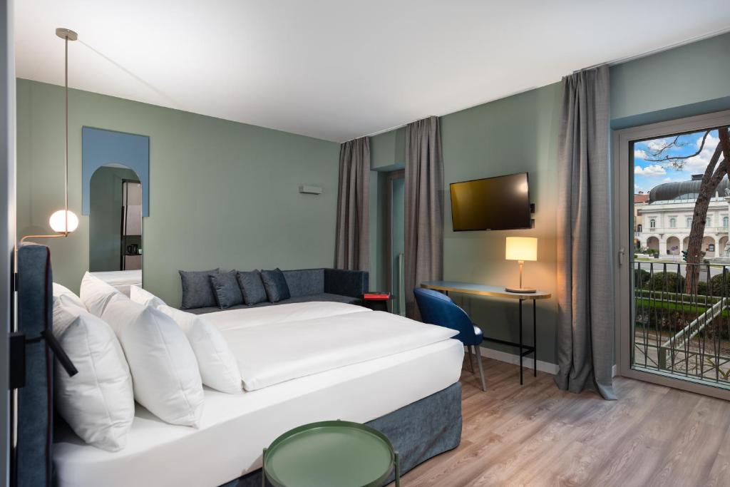 A bed or beds in a room at HT Hotel Trieste