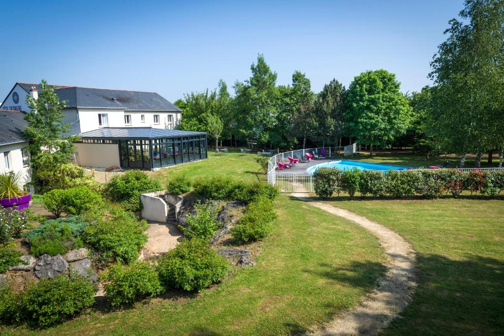einen Hof mit einem Pool und einem Gebäude in der Unterkunft The Originals City, Hôtel La Saulaie, Saumur Ouest (Inter-Hotel) in Doué-la-Fontaine