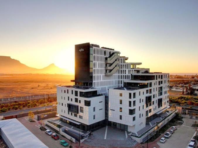 a large white building in a city with cars at Axis - Century City Self Catering Apartment in Cape Town
