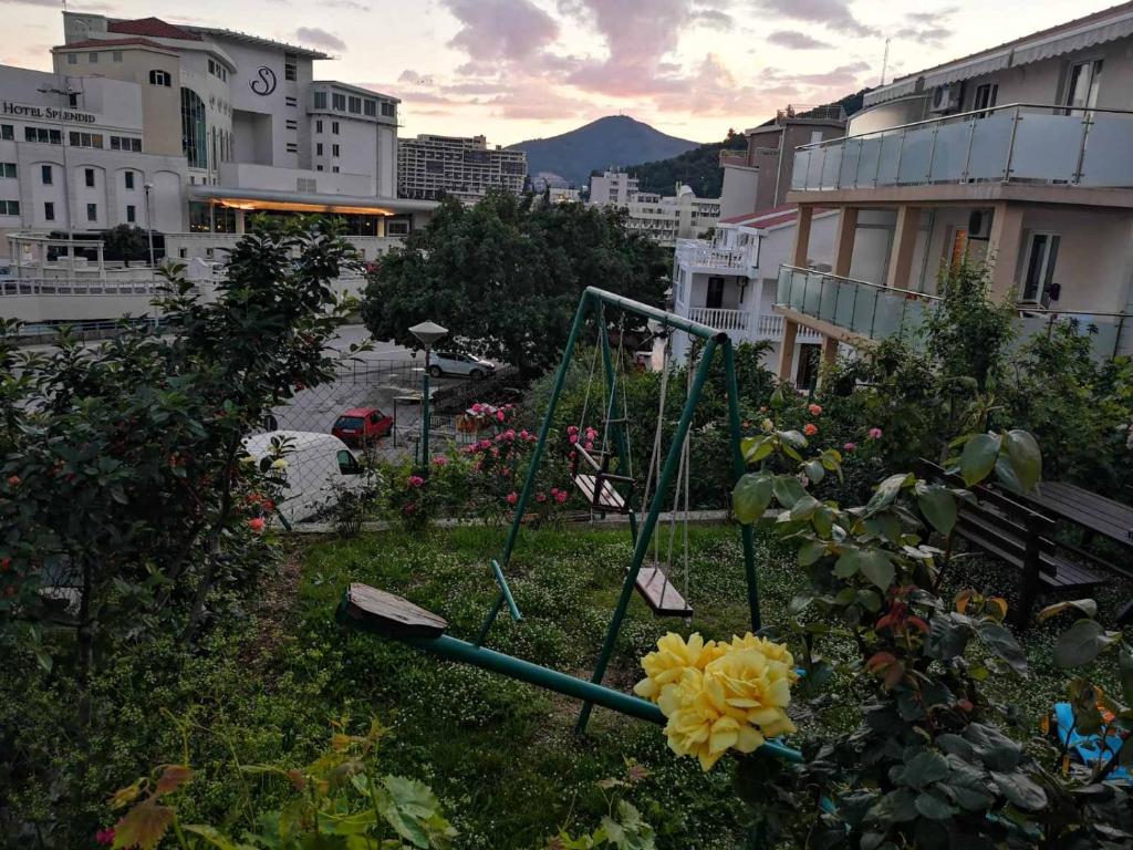 a park with a swing in the middle of a city at Apartmani Becici in Bečići
