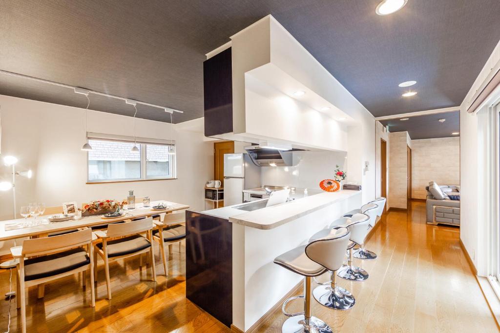 THE WORLDWIDE HOUSE في سابورو: مطبخ مع كونتر وكراسي في غرفة