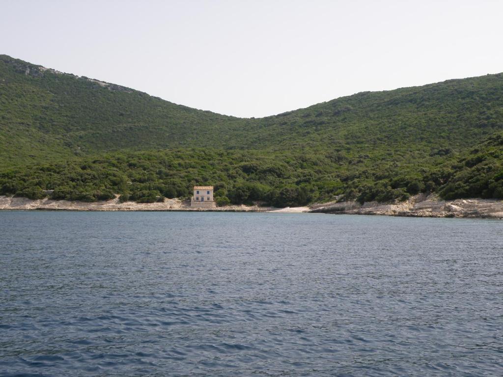 a large body of water with a house in the distance at Lošinj house robinson Vinodarska, Island Lošinj in Nerezine