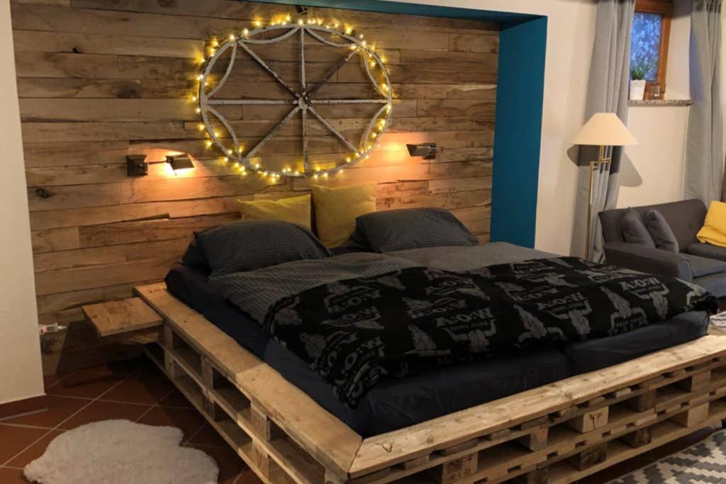 een slaapkamer met een groot bed en een houten muur bij Wohlfühlen mitten in Wacken in Wacken