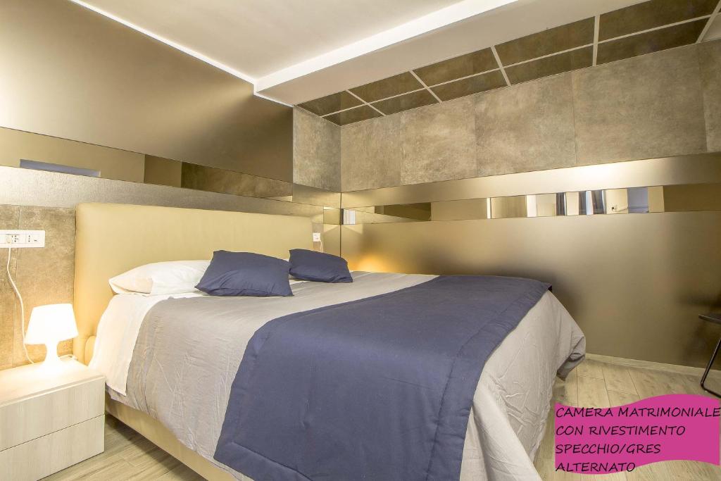 a bedroom with a large bed with blue sheets at Le Dimore in Centro con Parcheggio e Self check-in in Matera