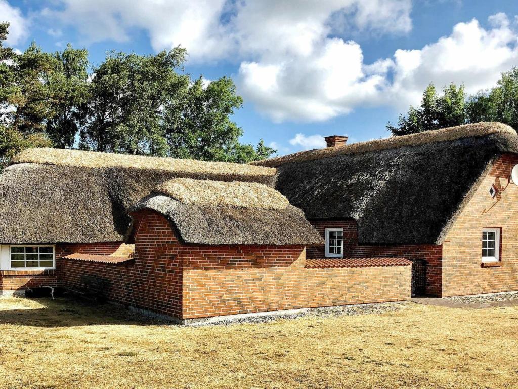 a large brick building with a thatched roof at 12 person holiday home in V ggerl se in Marielyst