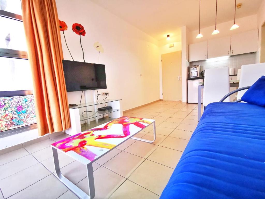 a living room with a bed and a table at Migdal Palace in Eilat