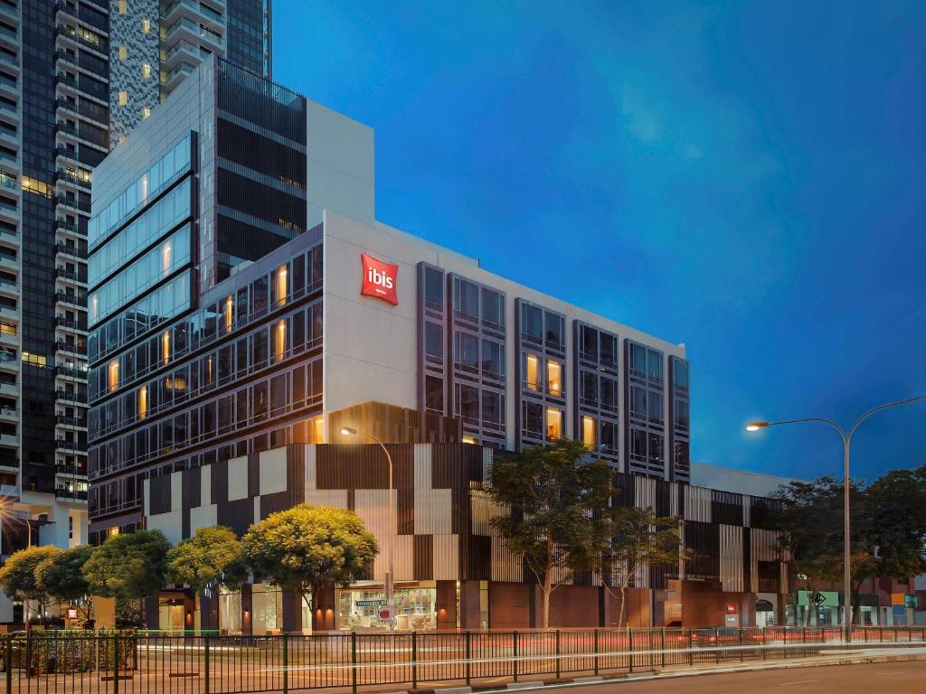 a building with a red sign on the side of it at Ibis Singapore Novena in Singapore