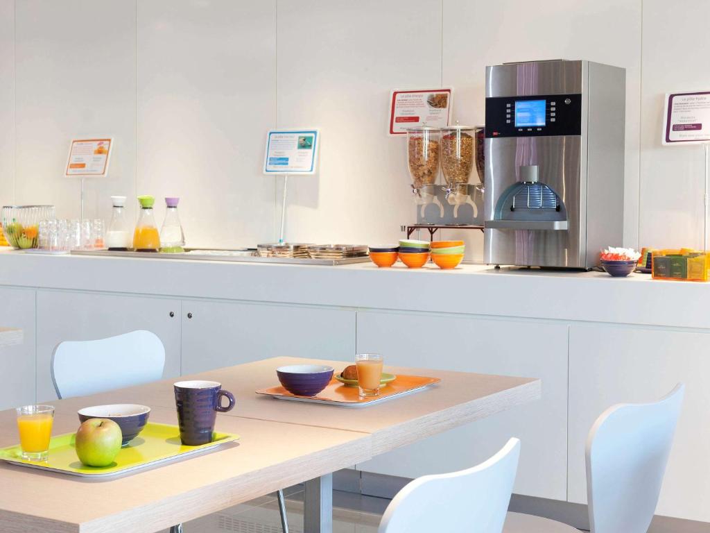 a kitchen with a table with two plates of food at ibis Styles Nimes Gare Centre in Nîmes