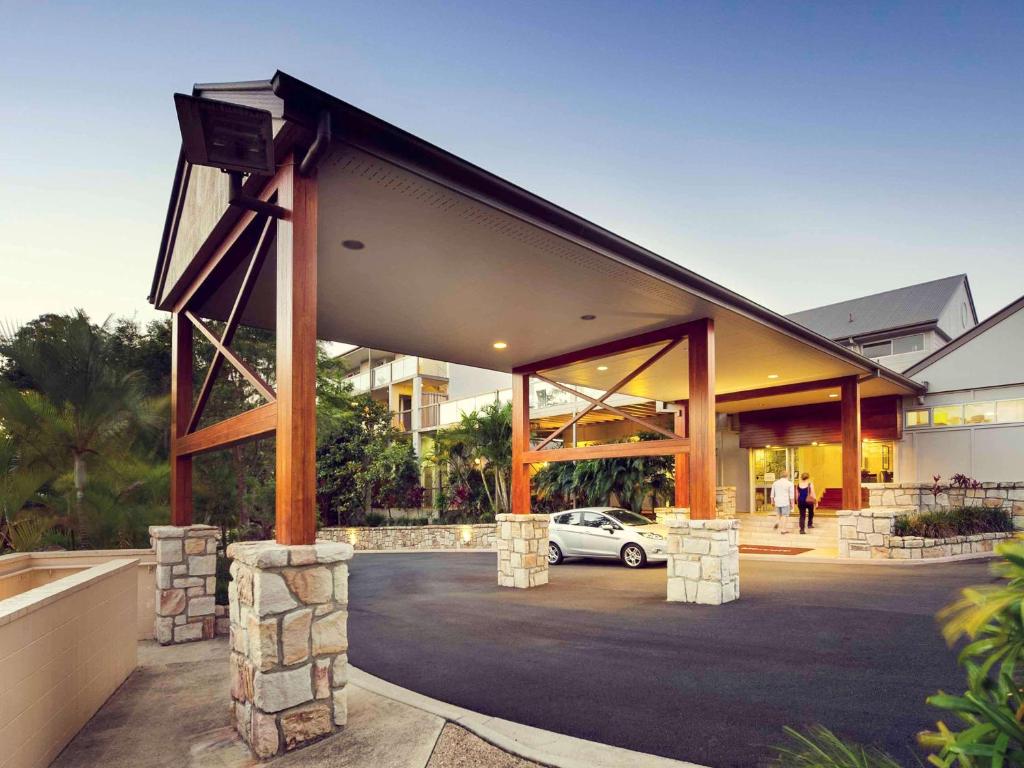 a building with a car parked in a parking lot at Mercure Clear Mountain Lodge in Mount Samson