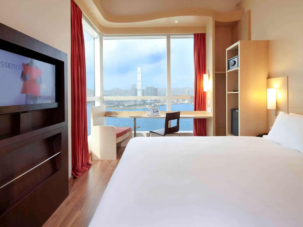 a hotel room with a bed and a large window at Ibis Hong Kong Central & Sheung Wan in Hong Kong