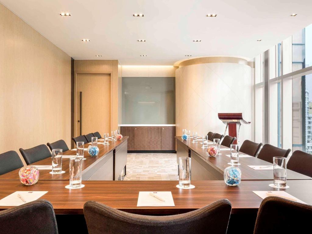 a meeting room with a long table and chairs at Ibis Hong Kong Central & Sheung Wan in Hong Kong