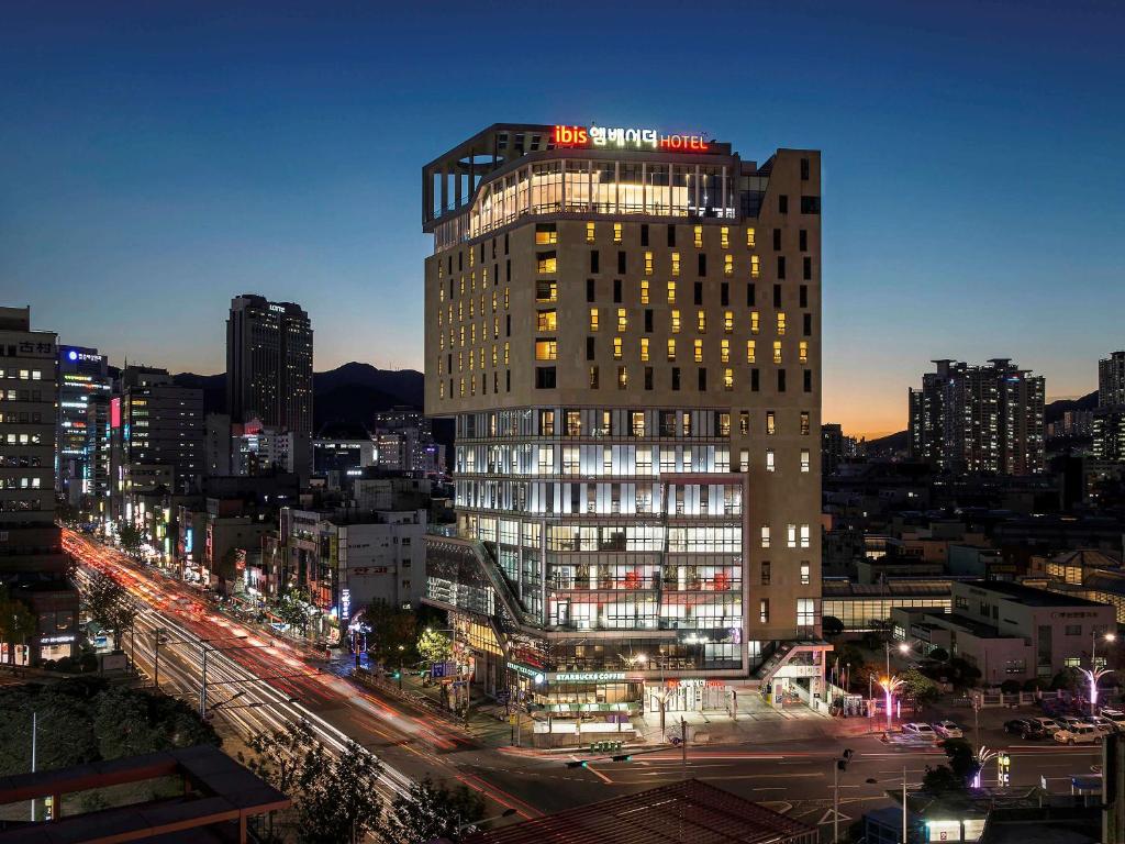 釜山にあるイビス アンバサダー プサン シティセンターの看板が上がる高層ビル