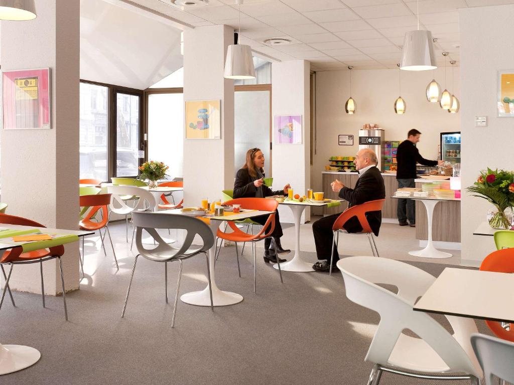 people sitting at tables in an office cafeteria at ibis Styles Grenoble Centre Gare in Grenoble