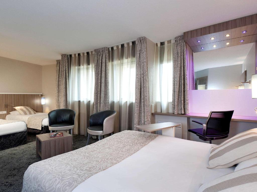 Habitación de hotel con 2 camas y 2 sillas en ibis Styles Melun en Rubelles